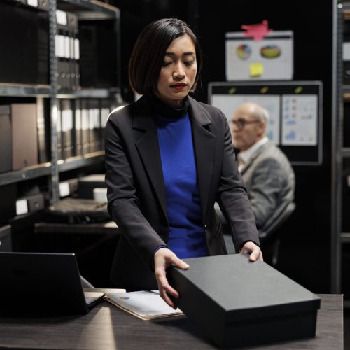 Bookkeeper storing revenue paperwork Asian manager bookkeeper storing annual profit revenue paperwork before official business inspection. Bureaucratic workplace filled with graphic charts and file folders on shelves